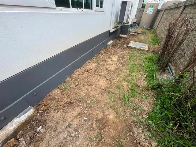 ผนังบ้านหลังปิดโพรงด้วยแผ่นเรียบสีเทาเข้ม